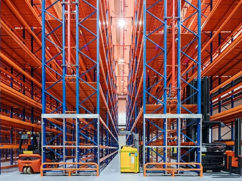 Fully automated very narrow aisle racking system in a modern distribution center, showing guided VNA trucks operating in ultra-narrow aisles.